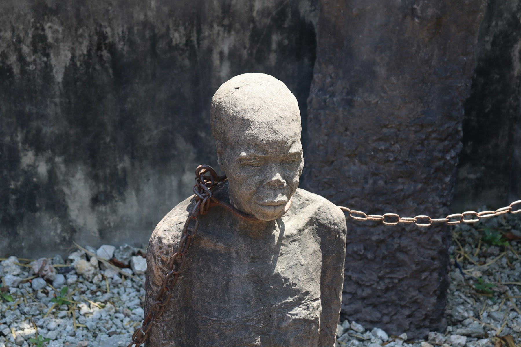 statue mémorielle représentant un homme enchaîné, sur le site de l'ancien marché aux esclaves de Zanzibar, à côté de la cathédrale Christ Church à Stone Town