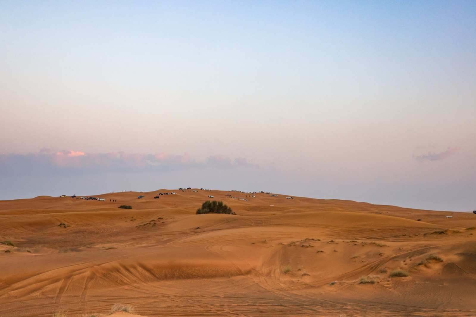 Véhicule 4x4 sur une piste désertique au coucher du soleil